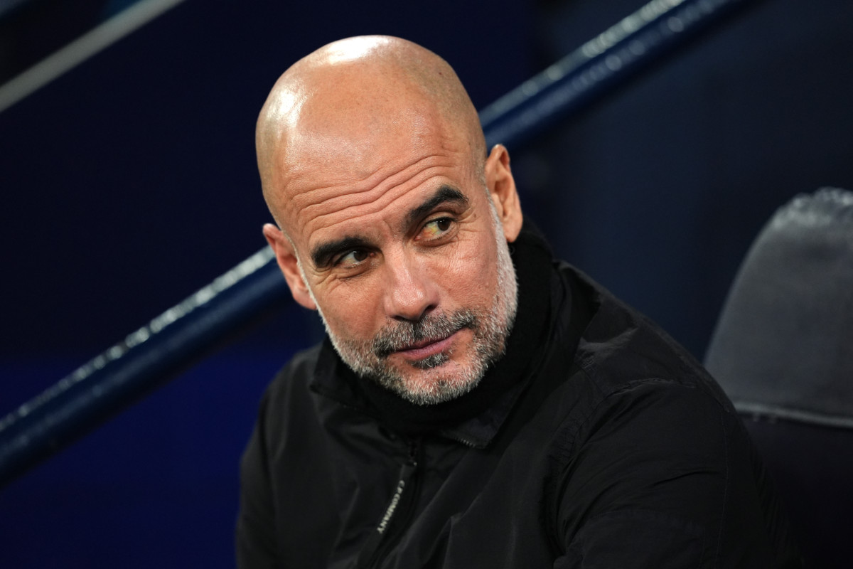 Pep Guardiola smiles on the Manchester City bench